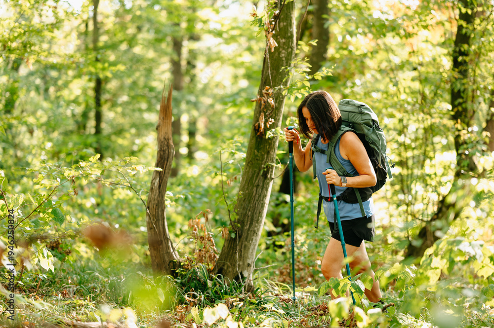 A woman embarks on an exciting journey, exploring natures wonders with her backpack in a vibrant forest A woman embarks on an exciting journey, exploring natures wonders with her backpack in a vibrant forest