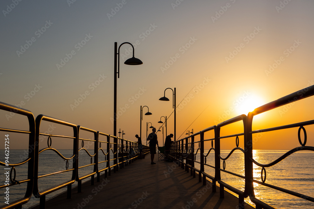 Fishermen fishing from pier at dawn’s first light Fishermen fishing from pier at dawn’s first light