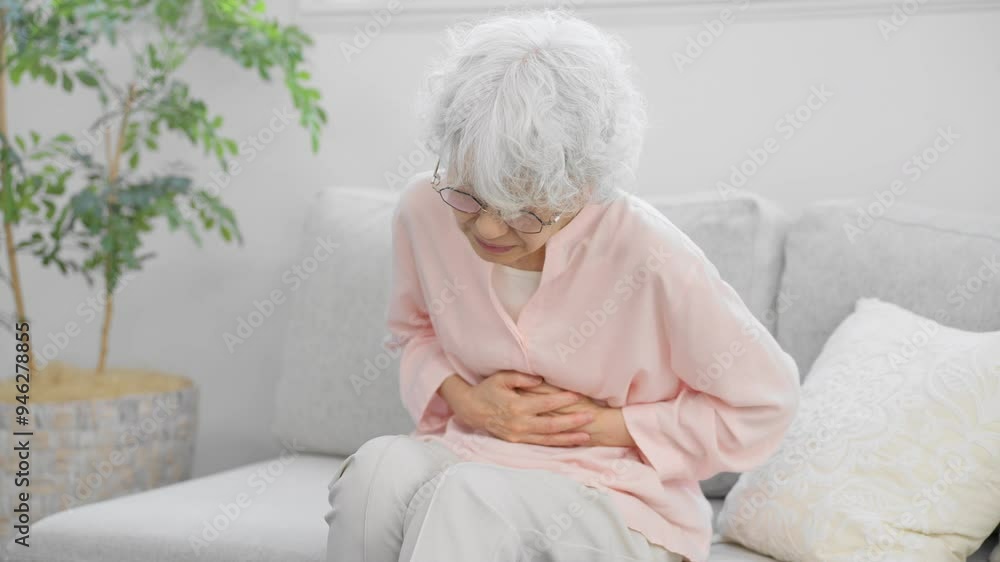 お腹を抱えるシニア女性
お腹を抱えるシニア女性