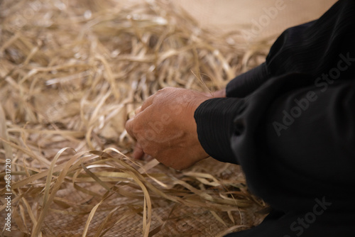 An Indonesian woman making a traditional woven mat