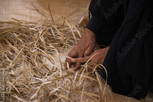 An Indonesian woman making a traditional woven mat
