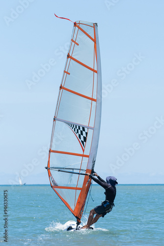 Obraz na płótnie A windsurfer plays with the wind and ocean waves
