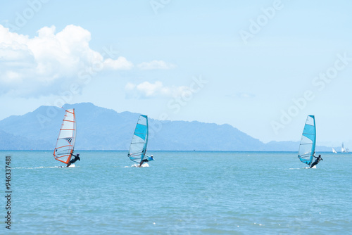 Some windsurfers plays with the wind and ocean waves