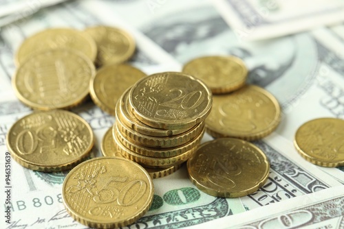 Many euro coins on dollar banknotes, closeup