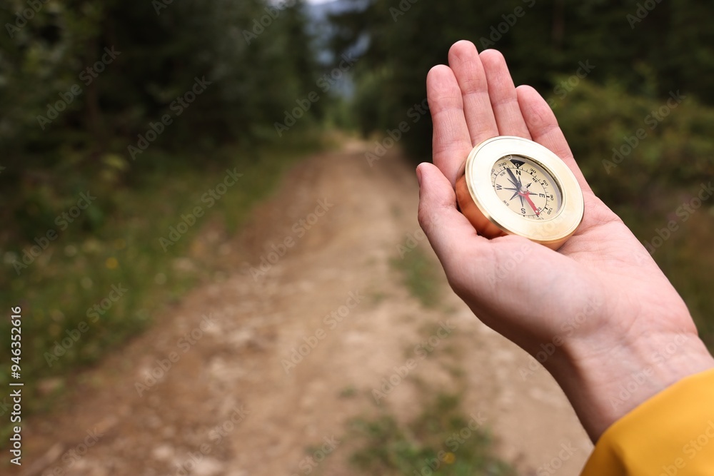 Woman holding compass near pathway outdoors, closeup. Space for text Woman holding compass near pathway outdoors, closeup. Space for text