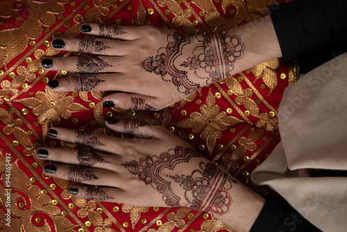 The bride's hands decorated with henna. There are many different names for henna tattoos around the world, such as mehndi, inai, hina, camphire, and hena. photo