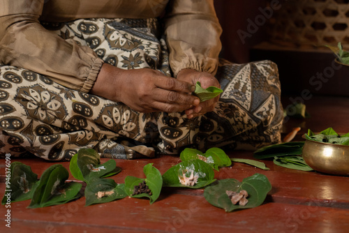 Obraz na plátně An asian woman prepares ingredients for betel nut chewing also called betel quid