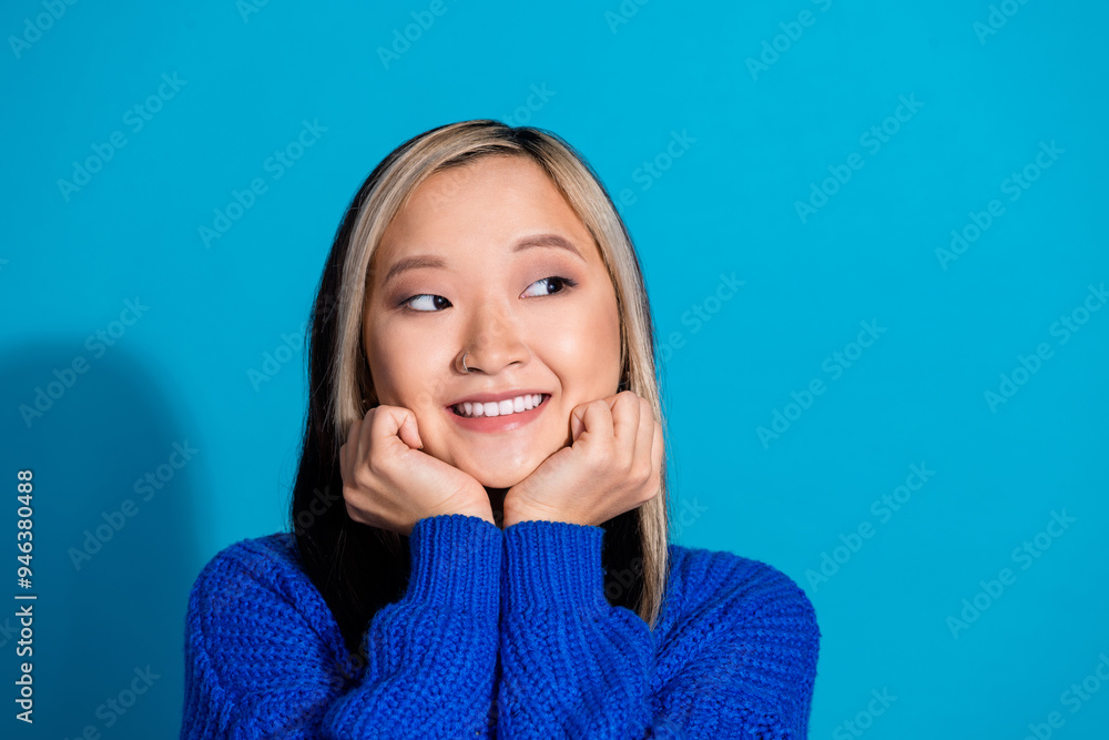 Photo portrait of pretty young girl look dreamy empty space wear trendy knitwear outfit isolated on blue color background Photo portrait of pretty young girl look dreamy empty space wear trendy knitwear outfit isolated on blue color background