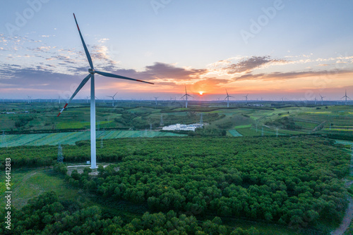 view of wind power turbine in field at sunset