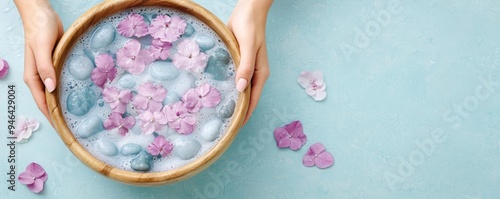 A woman enjoying a flowerinfused bath in a wooden tub, with hot stones placed on the rim photo