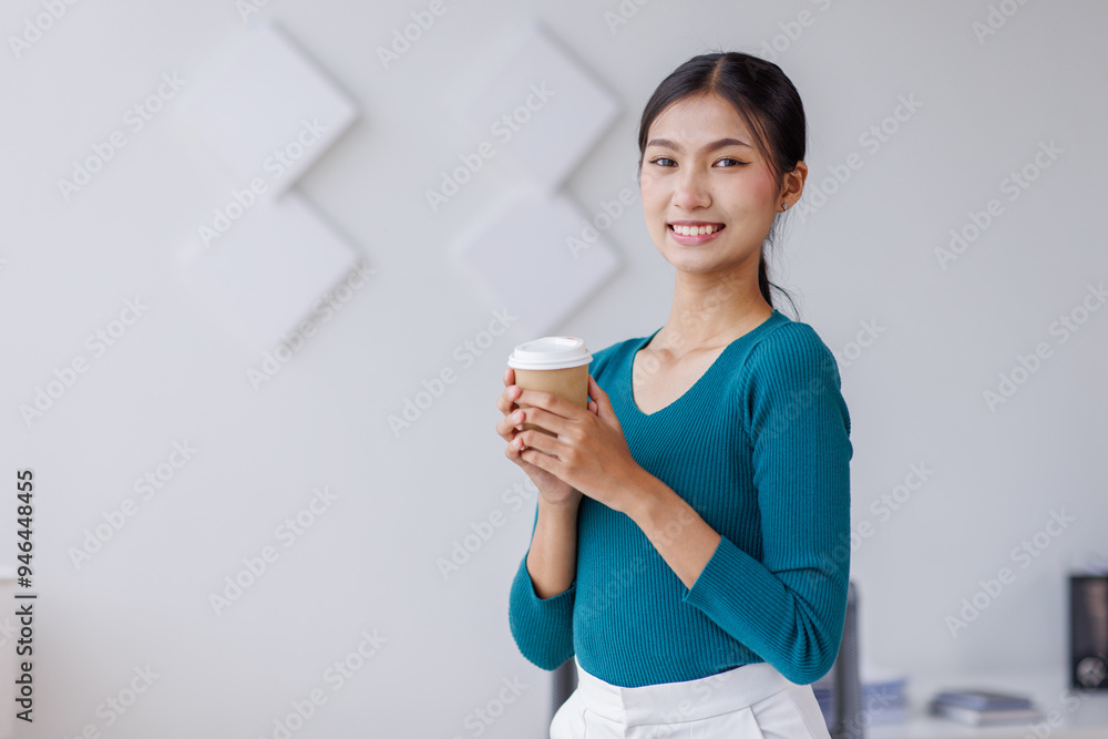 Young successful employee business asian woman in blue shirt work hold takeaway delivery craft paper cup coffee to go stand at desk with laptop pc computer at office. Young successful employee business asian woman in blue shirt work hold takeaway delivery craft paper cup coffee to go stand at desk with laptop pc computer at office.