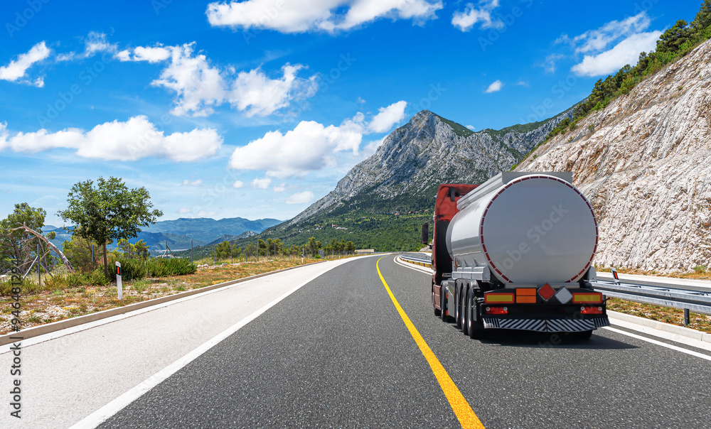 Fuel truck on a picturesque road. A silver tank truck transports fuel.
