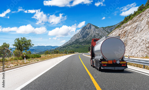 Obraz na płótnie Fuel truck on a picturesque road. A silver tank truck transports fuel. w salonie
