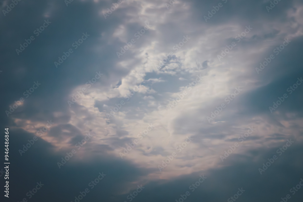 The sky is cloudy and the sun is barely visible. The clouds are dark and the sky is mostly grey The sky is cloudy and the sun is barely visible. The clouds are dark and the sky is mostly grey