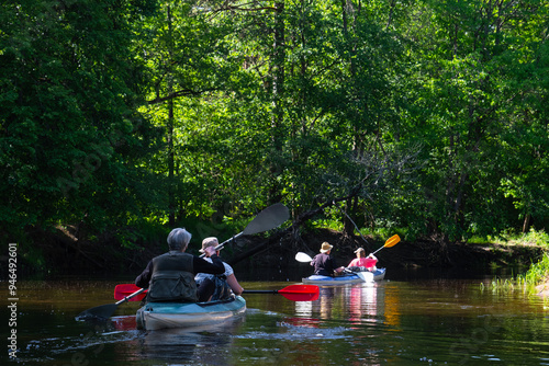 Group kayak trip for seigneur and senora . An elderly couple And adult rowing boat on the river, a water hike, a summer adventure. Age-related sports, mental youth and health, tourism, active old age photo