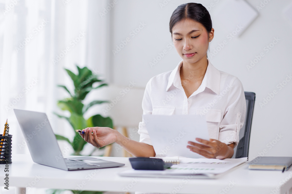 Asian Business woman using calculator and laptop for doing math finance on an office desk, tax, report, accounting, statistics, and analytical research concept
Asian Business woman using calculator and laptop for doing math finance on an office desk, tax, report, accounting, statistics, and analytical research concept