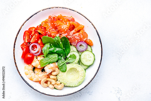 Fotografie Seafood salad poke bowl with shrimp, salmon, avocado, spinach, cucumber, tomato, cashew, sesame seeds