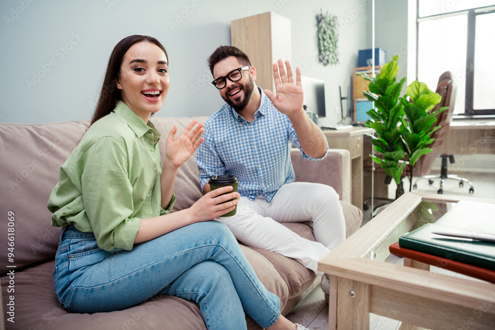 Photo of positive good mood employers dressed shirts drinking beverages waving arms hi indoors workshop workstation Photo of positive good mood employers dressed shirts drinking beverages waving arms hi indoors workshop workstation