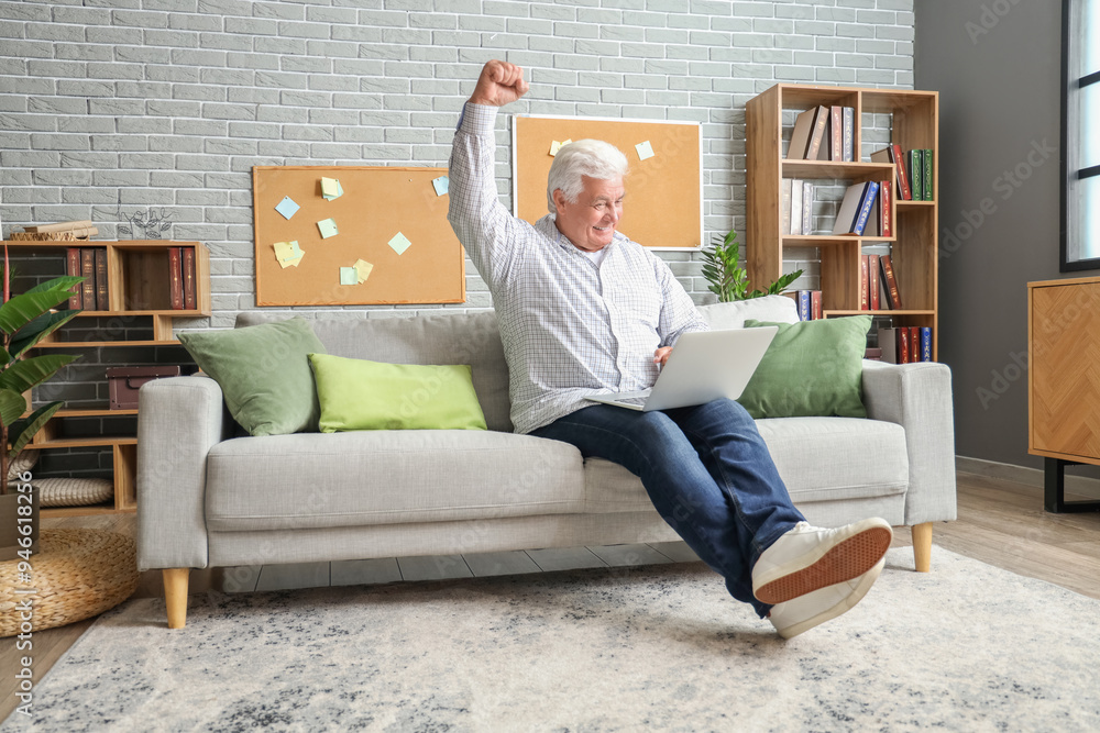 Happy senior man using laptop on sofa at home Happy senior man using laptop on sofa at home