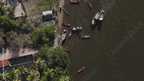 Aerial view of the coast of the Preguicas River with palm trees, boats and houses with roofs in Maranhao, Brazil. Nature, boats, sailing, calm, trees, water, clean, slow, jungle, travel, vacation. photo