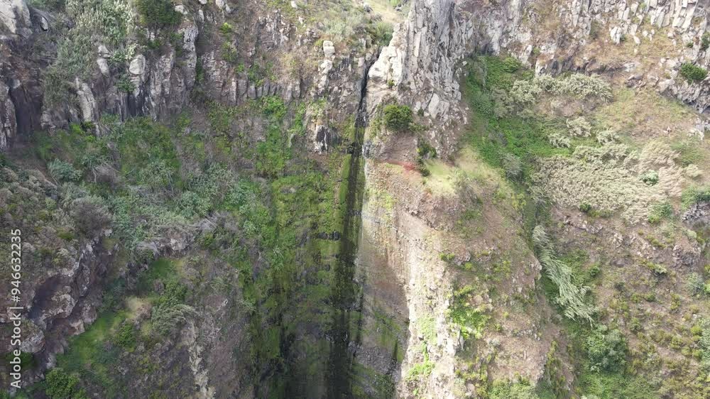 Drone approximation to Garganta Funda waterfall, Madeira. Rugged, dramatic landscape and popular spot for visitors due to its impressive drop and the stunning natural Drone approximation to Garganta Funda waterfall, Madeira. Rugged, dramatic landscape and popular spot for visitors due to its impressive drop and the stunning natural