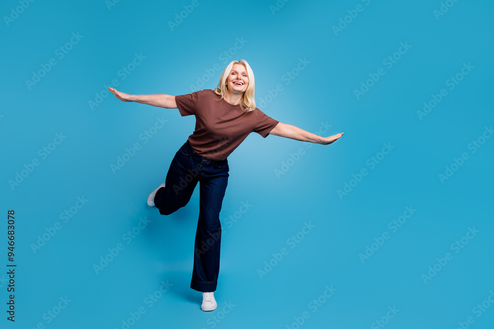 Fototapeta premium Photo of lovely nice senior woman wear stylish brown clothes have fun fly air isolated on blue color background