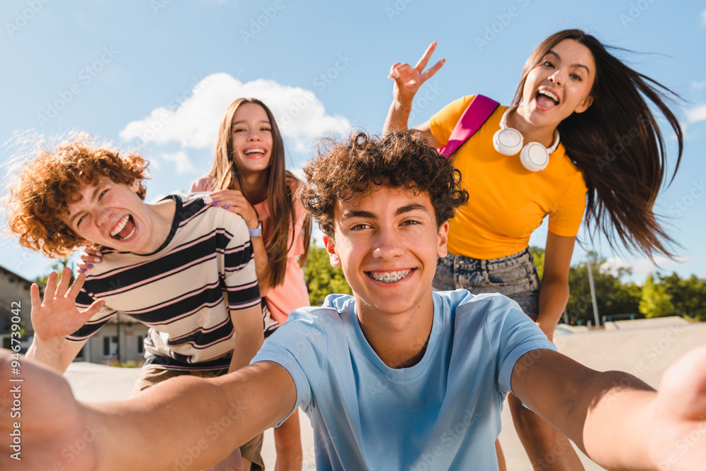 Naklejka premium Selfie shot of crazy young people friends college students school pupils classmates teenagers having fun together spend time summer weekend in skate park outside urban street. Friendship concept