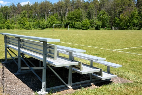 Fotografie Aluminum bleachers sit empty at a soccer and sports field on a sunny summer day