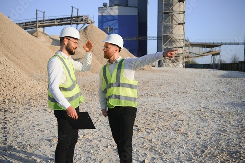 Two engineers or businessmen at an industrial plant. Plant for extraction and production of gravel