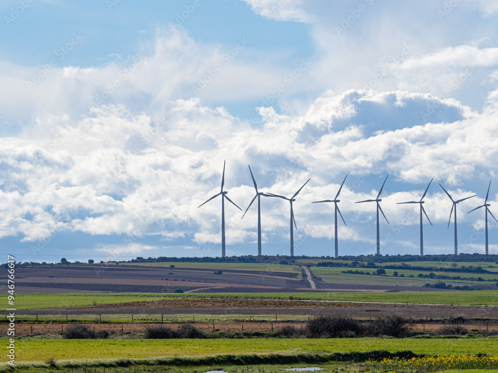 Wind farm between crop fields. Blue sky with clouds Wind farm between crop fields. Blue sky with clouds