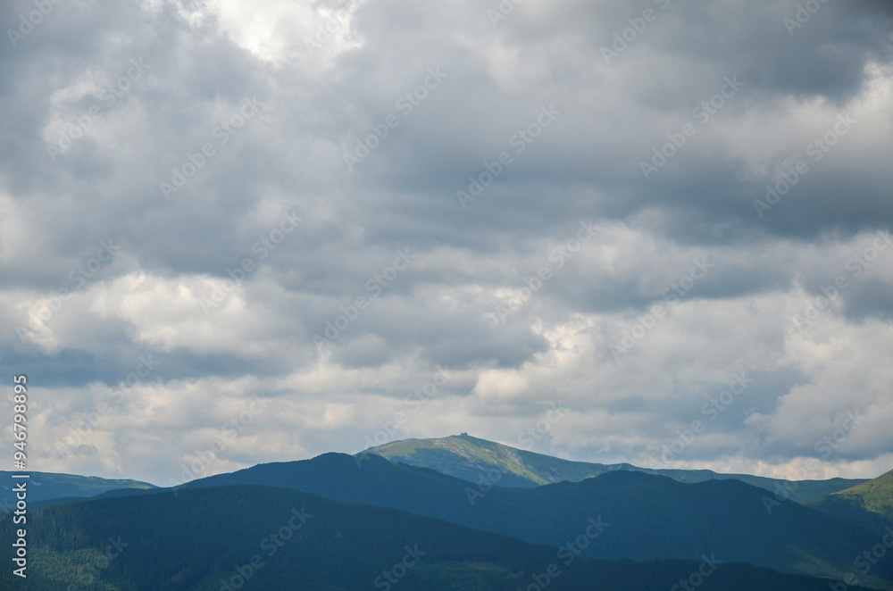 Chornohora mountain range with mount Pip Ivan with the ruins of the observatory on top under a low cloudy sky. Carpathian Mountains, Ukraine Chornohora mountain range with mount Pip Ivan with the ruins of the observatory on top under a low cloudy sky. Carpathian Mountains, Ukraine
