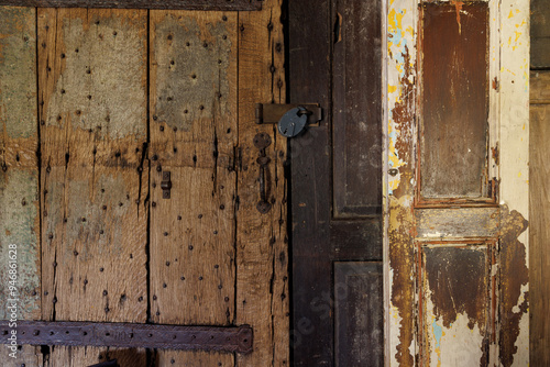 The door is old and has a lock on it. The door is made of wood and has a rustic appearance