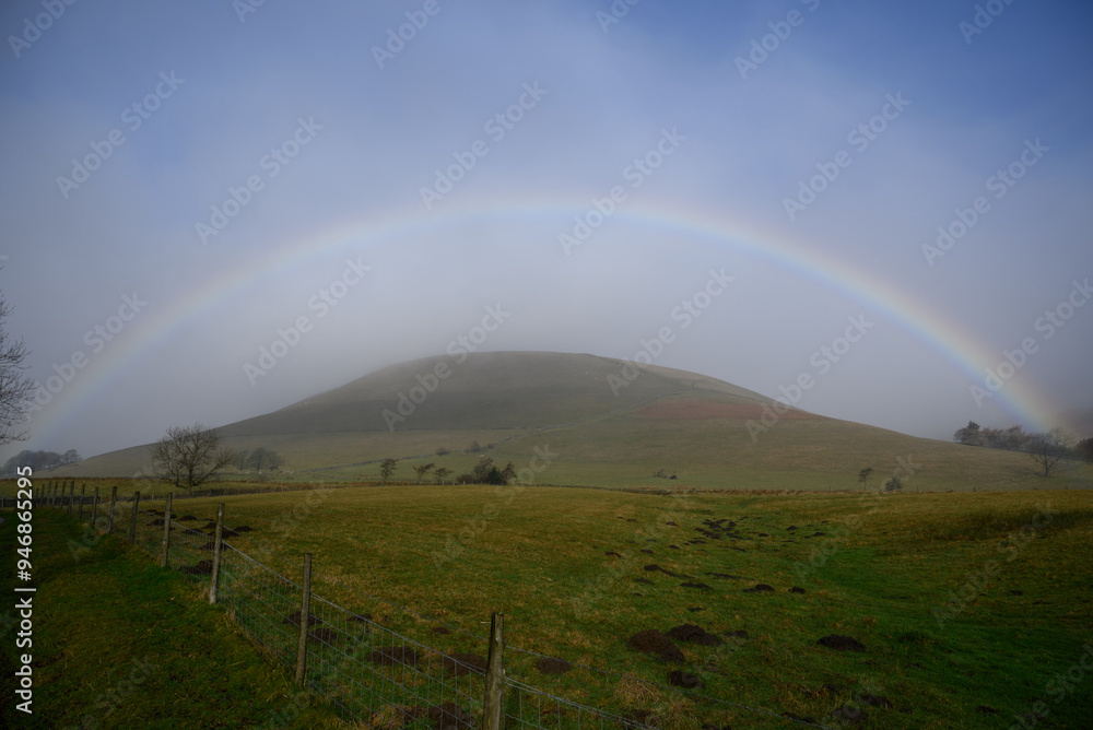 Majestic Rainbow Over a Hill: Vibrant Colors of the Rainbow Illuminating the Scenic Hill and Surrounding Nature Majestic Rainbow Over a Hill: Vibrant Colors of the Rainbow Illuminating the Scenic Hill and Surrounding Nature