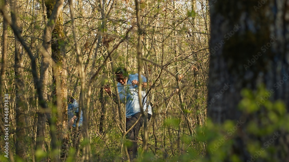 Group of lifesavers volunteers searching for a missing person, calling their name in the woods and going through the trees to track steps. Search squad rescuers looking for a lost victim. Camera A. Group of lifesavers volunteers searching for a missing person, calling their name in the woods and going through the trees to track steps. Search squad rescuers looking for a lost victim. Camera A.