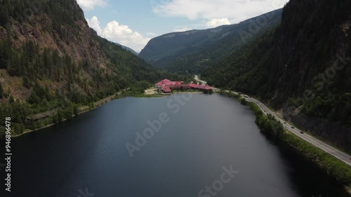 Aerial revealing shot over Three Valley Lake overlooking a distant mountain chalet along the Trans Canada Highway and CP Rail train tracks.
 photo