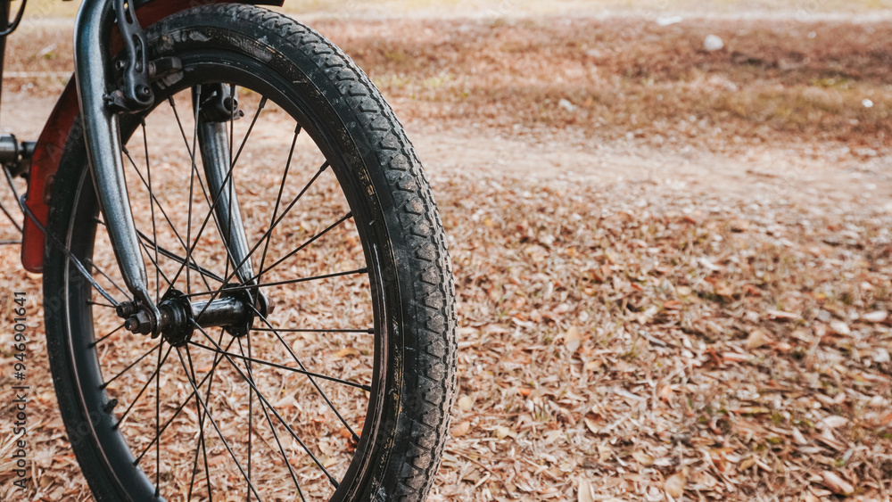 Perspective shot of a bicycle front wheel on a leaf-covered path, capturing the essence of outdoor cycling Perspective shot of a bicycle front wheel on a leaf-covered path, capturing the essence of outdoor cycling