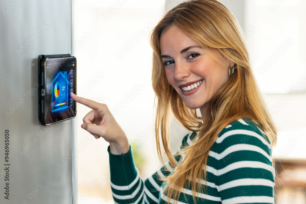 Pretty young woman using the home automation system on digital tablet to regulate the temperature. Pretty young woman using the home automation system on digital tablet to regulate the temperature.