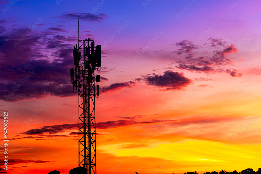 Fototapeta premium Telecommunication towers with colorful sky as a backdrop in the morning and sunlight reflecting off clouds create a stunning and mesmerizing light effect. Concept of innovation, technology and environ