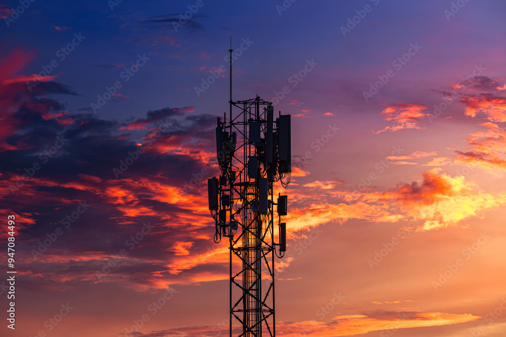 Fototapeta premium Telecommunication towers with colorful sky as a backdrop in the morning and sunlight reflecting off clouds create a stunning and mesmerizing light effect. Concept of innovation, technology and environ