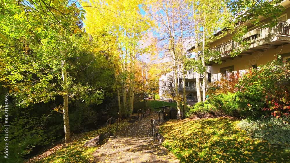 Vail Colorado village in autumn fall with leaves flying in wind from yellow aspen trees at residential condo apartment buildings Vail Colorado village in autumn fall with leaves flying in wind from yellow aspen trees at residential condo apartment buildings