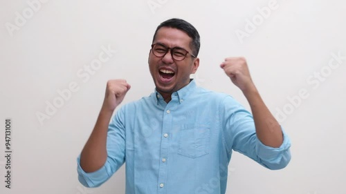 A man dancing happily after looking at something with suprised expression