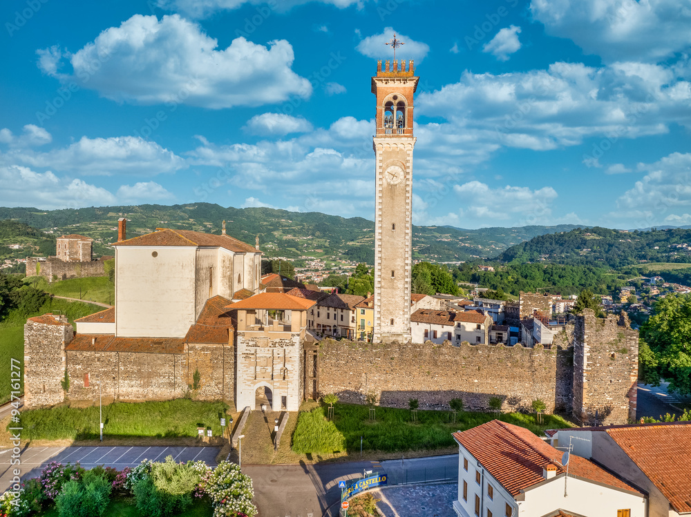 Aerial view of Arzignano castle with medieval walled town, tall clock tower, fortified gates, turrets, towers, in the middle of a vineyard in Veneto Italy