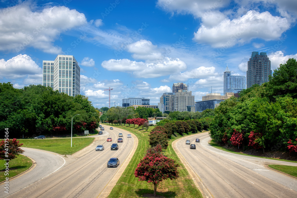 Obraz premium A cityscape of Raleigh, North Carolina with cars traveling out of the capital city on a summer day. HDR.