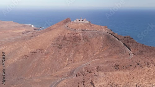 Aerial view of Faro de la Entallada with winding road and rugged coastline, Las Playitas, Fuerteventura, Spain. photo