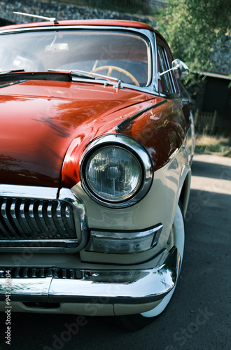 Vintage car headlight close-up. Classic automobile front light detail. Retro vehicle chrome trim and glass lens design element