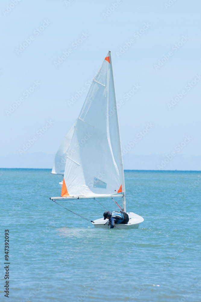 Naklejka premium Sailors are having fun using a small sailboat at sea