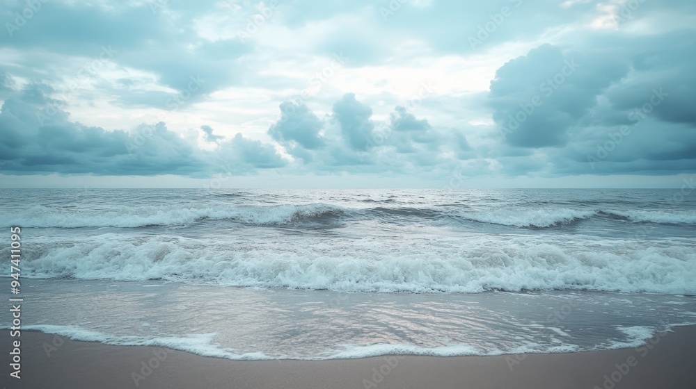 Fototapeta premium Serene Beachscape with Gentle Waves under Cloudy Skies