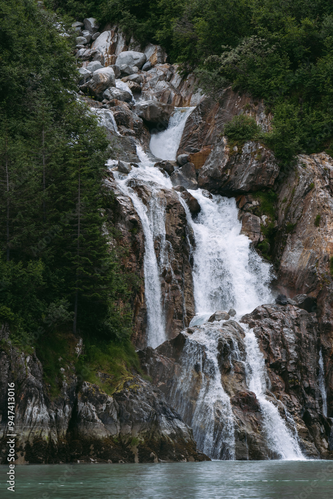 Waterfall in Tracy Arm fjord south of Juneau Alaska in Tongass National Forest during summer Waterfall in Tracy Arm fjord south of Juneau Alaska in Tongass National Forest during summer