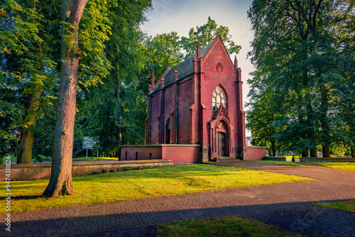 Stunning evening view of brick chapel near Stanislawa Kostki Catholic church. Amazing summser sunset in Karnice village, Gryfice County, West Pomerania, Poland, Europe. Traveling concept background.