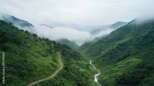 Aerial View of Lush Green Mountains with Fog and Winding Road